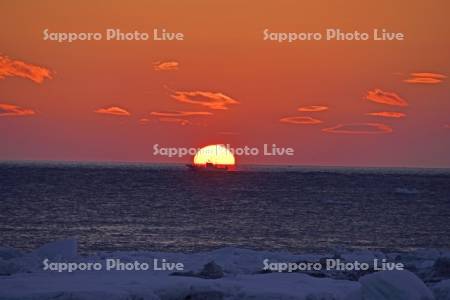 朝日とホタテ漁船と流氷