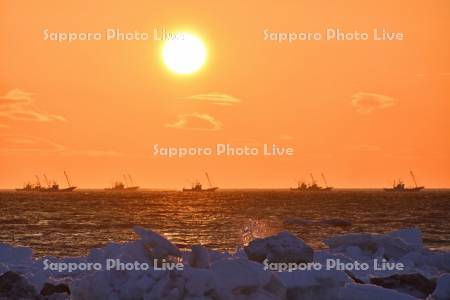 朝日とホタテ漁船と流氷