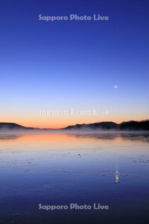 凍る屈斜路湖の気嵐と夜明けの月