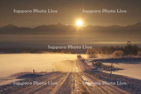 十勝岳連峰の日の出と朝霧と道