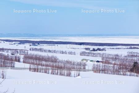 オホーツク海の流氷と雪の田園風景