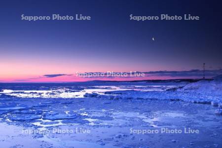 日の出岬の朝の流氷と月とオホーツク海