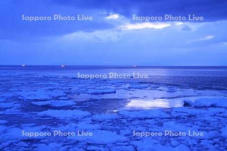 朝の流氷と国後島とスケソウダラ漁船
