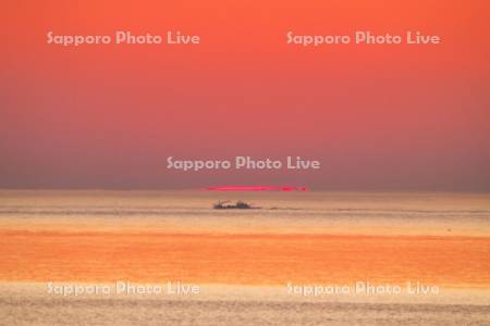 オホーツク海の日の出と漁船