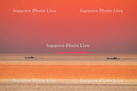 オホーツク海の日の出と漁船