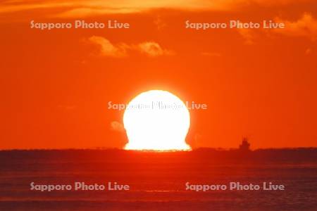 日の出（ダルマ型太陽）と太平洋と漁船