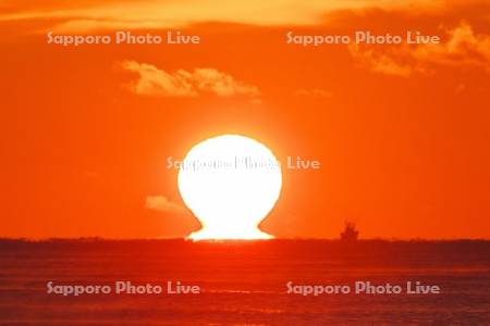 日の出（ダルマ型太陽）と太平洋と漁船