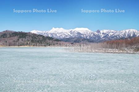 氷の残るシューパロ湖と夕張山地