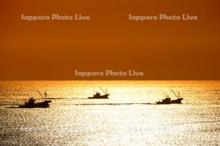 朝陽とホタテ漁船
