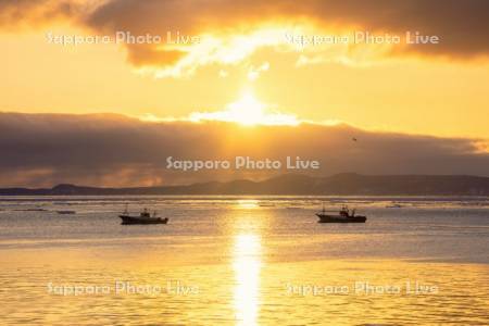 朝陽と漁船
