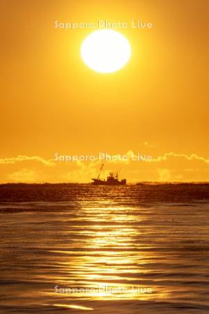 朝陽と漁船