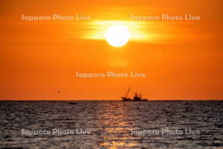 朝陽とホタテ漁船
