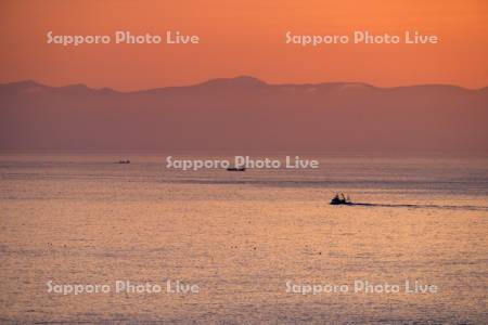 朝陽と漁船