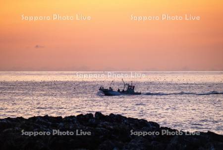 朝焼けと漁船