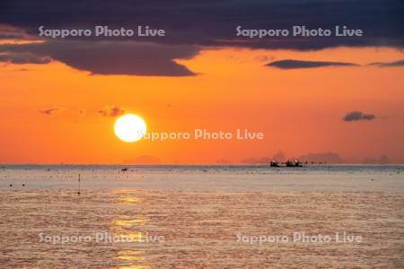 朝陽と漁船
