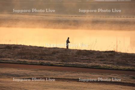 釣り人と川霧の釧路川