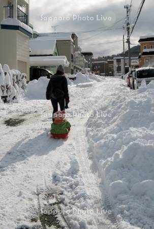 冬の住宅街　ソリを引く親子