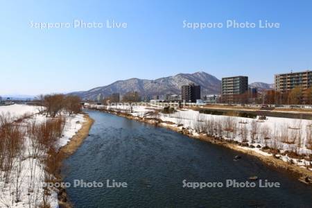 雪解けの豊平川と藻岩山