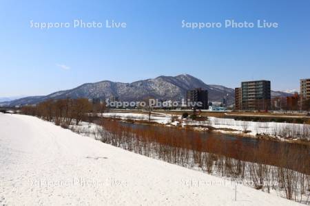 雪解けの豊平川と藻岩山