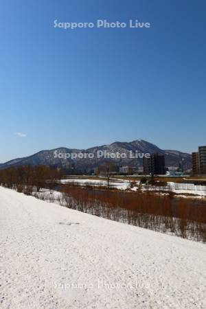 雪解けの豊平川と藻岩山